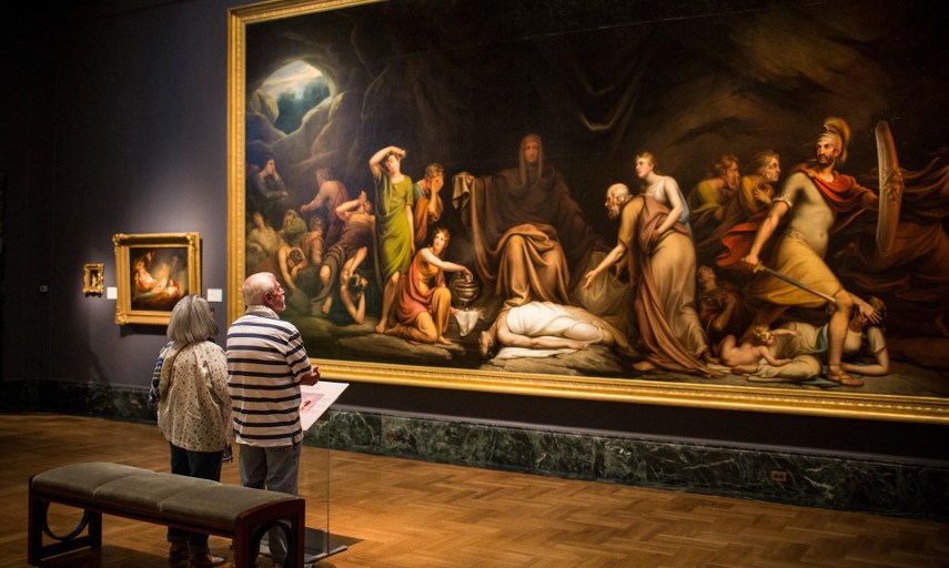 Photo of a man and a women looking at a painting and maybe wandering how to value art piece at the Detroit Institute of Arts 