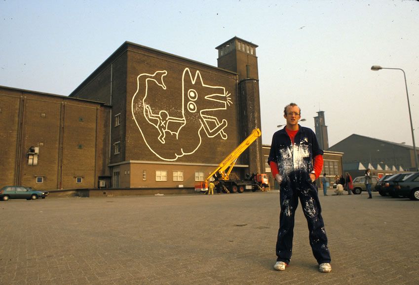 Keith Haring in front of the mural in Amsterdam
