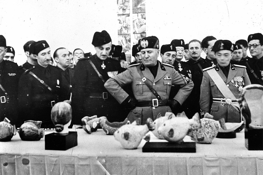 Mussolini inspecting ceramics on the street in Italy, 1930. He adopted innovations of Futurism art in his public speeches