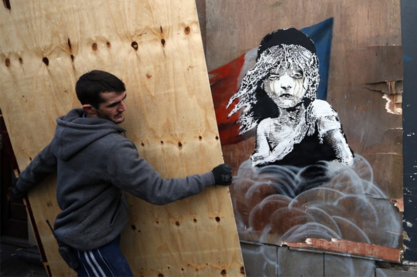 Worker covering up Banksy's artwork
