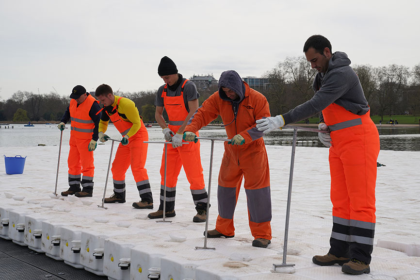 The workers screw together the cubes and pins to form the floating platform